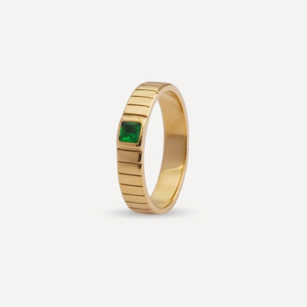 Unisex gold band ring from Rush featuring a ribbed design and green square-cut stone, blending minimalist elegance with a bold accent detail. rush gold ring with green emerald gemstone men women trendy popular chic ring 
